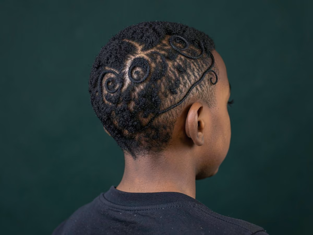 Boy with a black boys swirl design haircut
