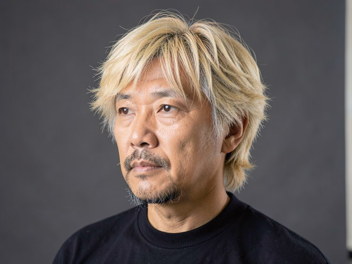 Man with a brad pitt shaggy hair with goatee