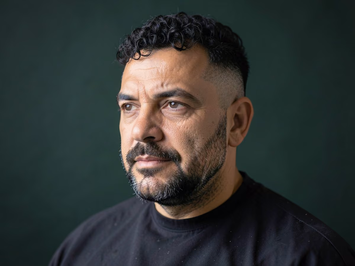 Man with a curly fade with stubble