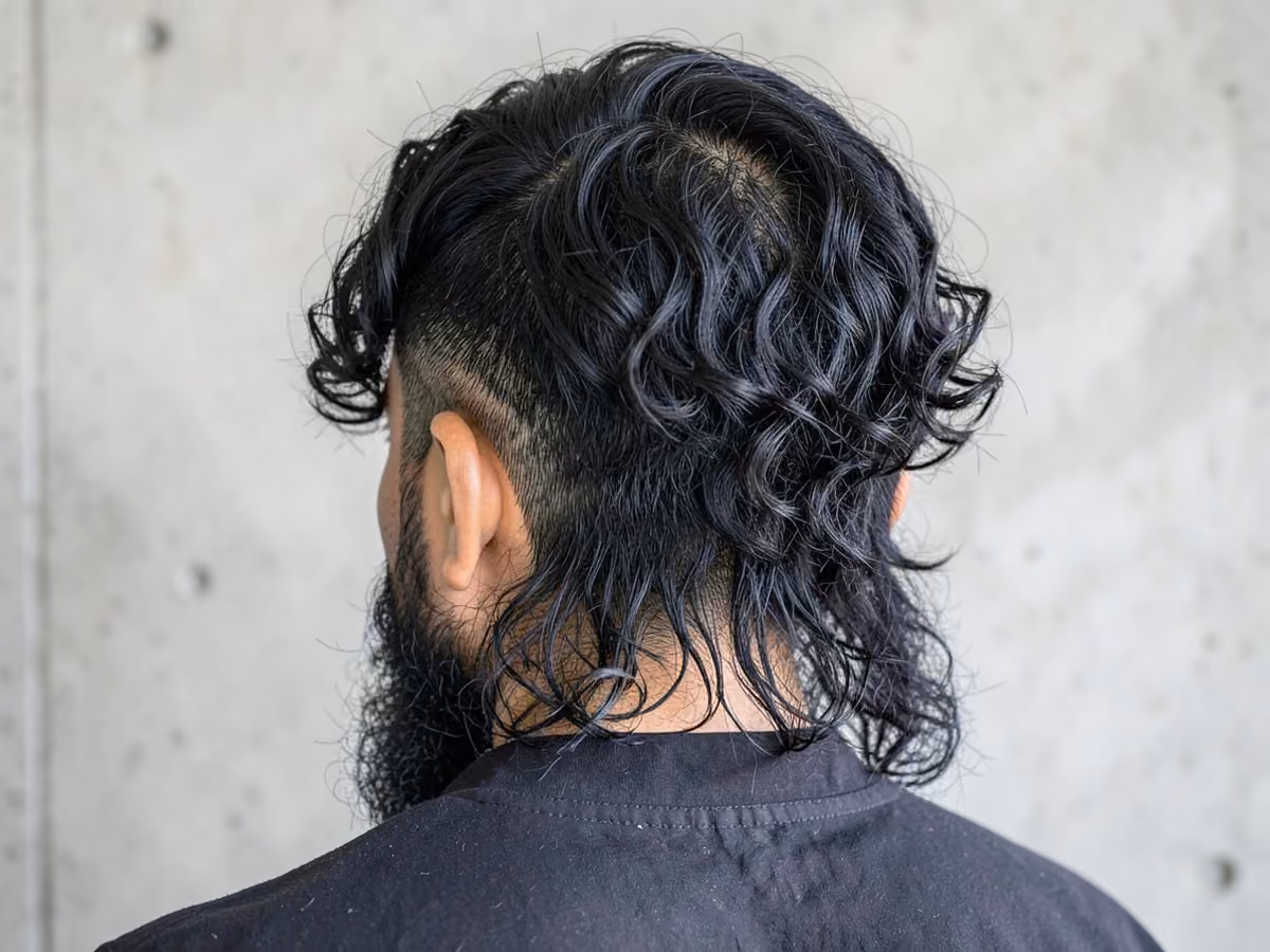 Man with a curly mullet undercut