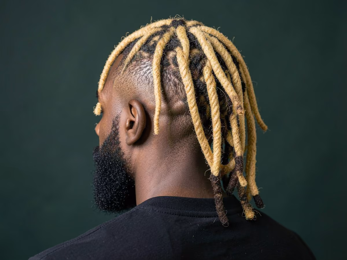Man with a honey blonde locs with taper haircut