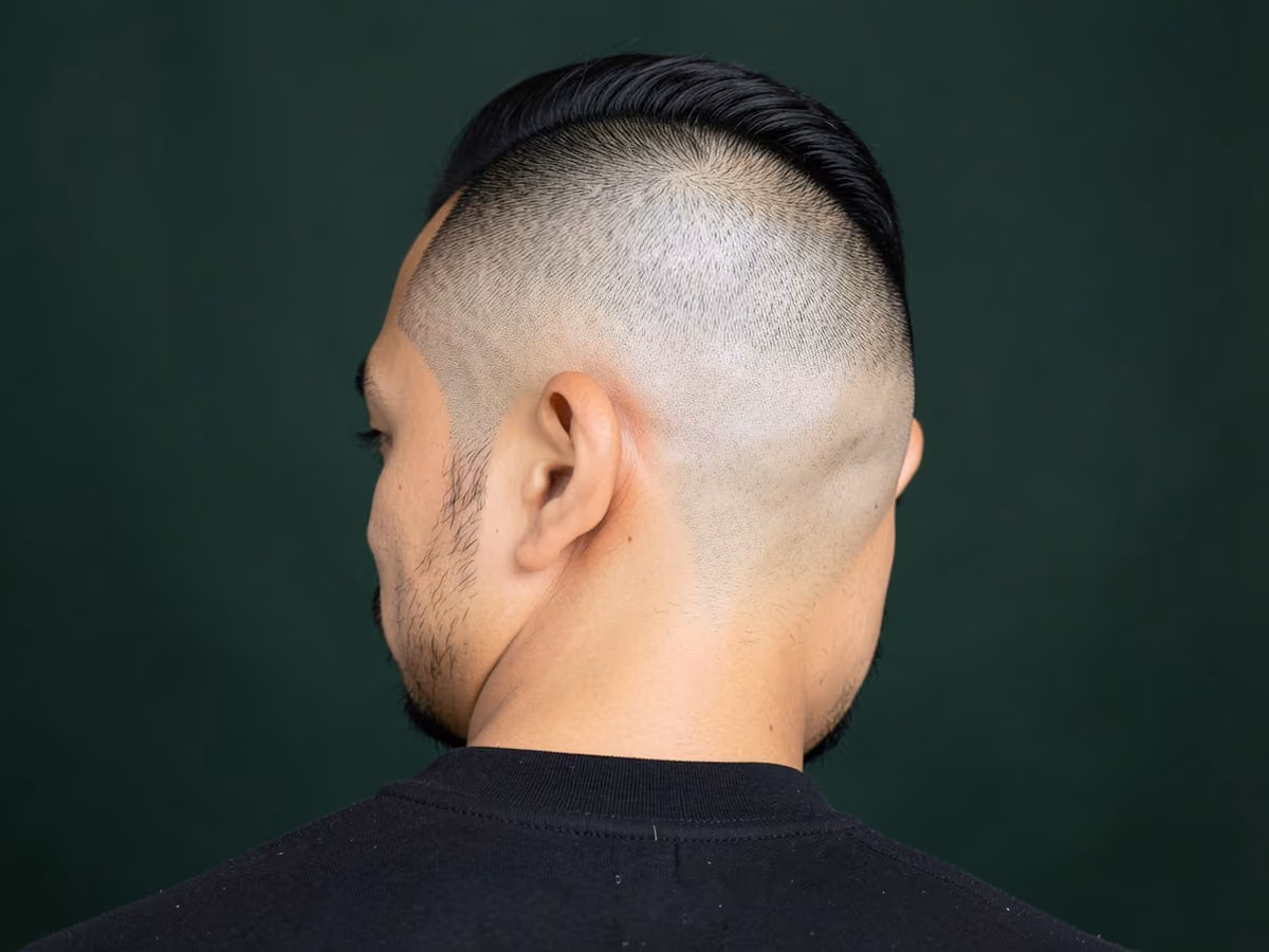 Man with a hard part with bald fade