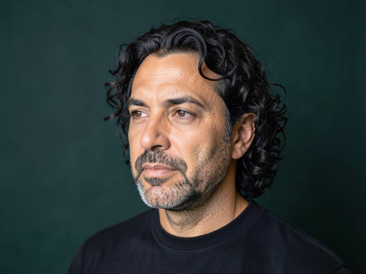 Man with a long curly hair with stubble