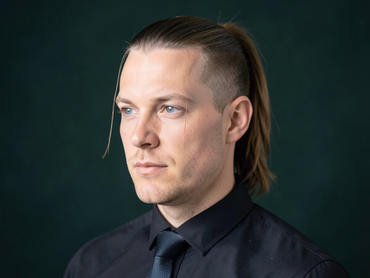 Man with a ponytail with face-framing strands haircut